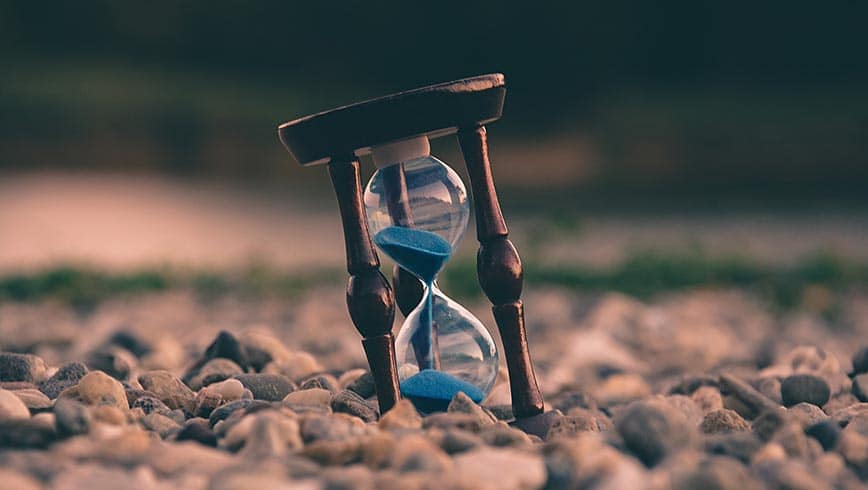 Reloj de arena medio enterrado en tierra