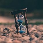Reloj de arena medio enterrado en tierra