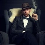 Hombre mafioso sentado en un sillón